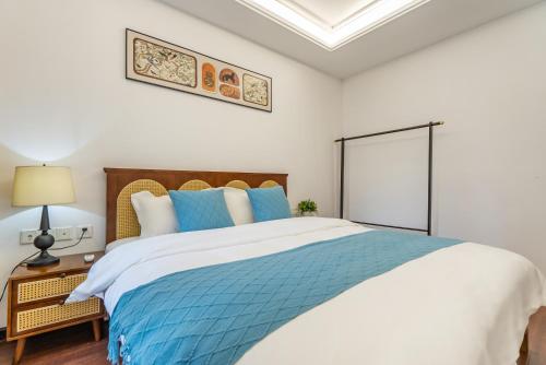 a bedroom with a large bed with blue pillows at Mist Nest Apartment in Chongqing