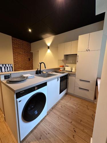 une cuisine avec un lave-linge au milieu dans l'établissement Suite Junior, à Saint-Brieuc