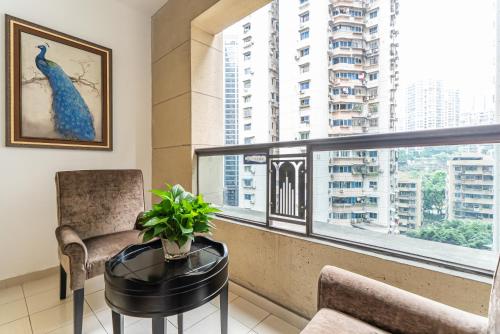 a balcony with a chair and a table and a window at Mist Nest Apartment in Chongqing