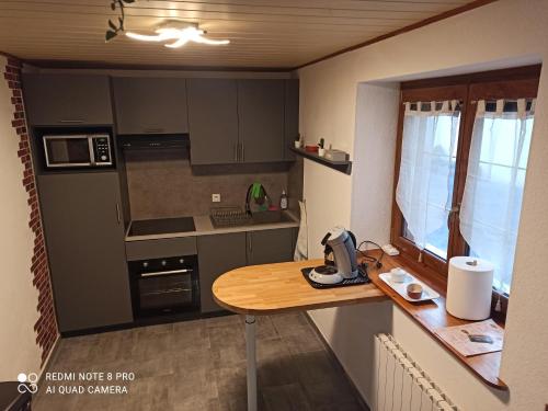une petite cuisine avec une table en bois. dans l'établissement Maison jumelée, à Wittenheim