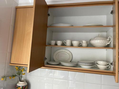 a cabinet with plates and cups and dishes in it at Casa Roma in Casinos