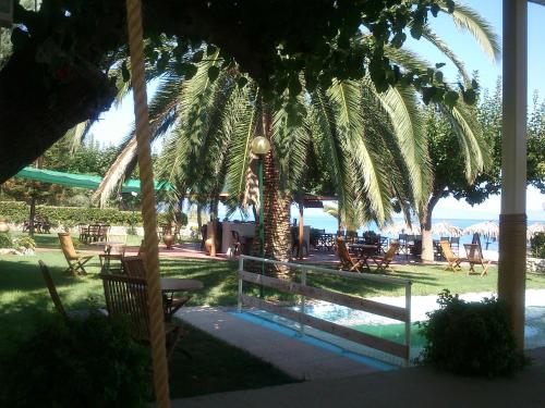 a view of a resort with chairs and palm trees at Evoikos beach & resort in Livanátai