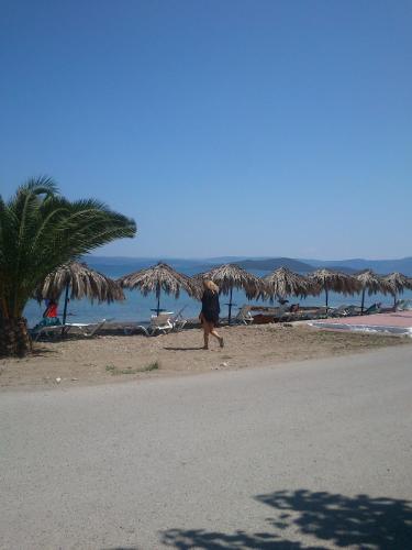 a person walking on the beach near the ocean at Evoikos beach & resort in Livanátai