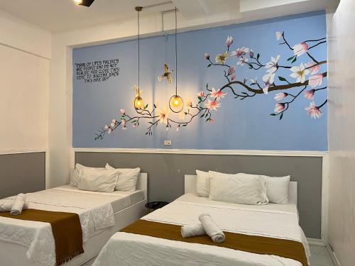 two beds in a room with a painting on the wall at Dajon #7 Superior STE-Generator & Starlink in General Luna