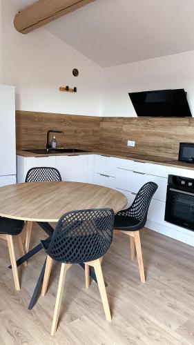 une cuisine avec une table en bois et deux chaises dans l'établissement Appartement T2, à Béziers
