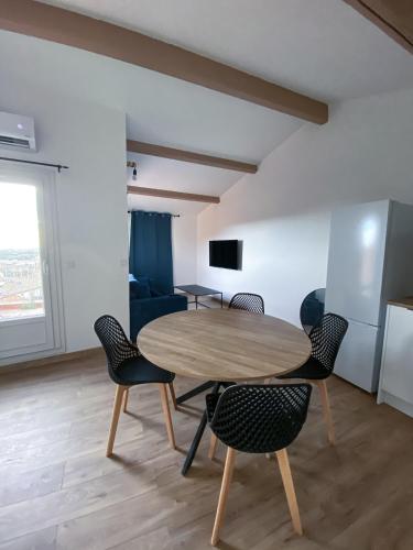 une salle à manger avec une table et des chaises en bois dans l'établissement Appartement T2, à Béziers