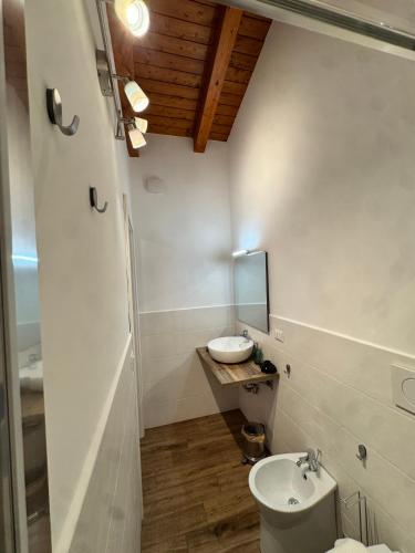 a white bathroom with a sink and a toilet at La Terrazza di Cirico' in Carlentini