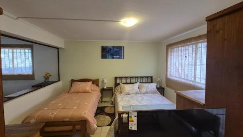 una camera con due letti e una tv di Departamento Centro La Serena a La Serena
