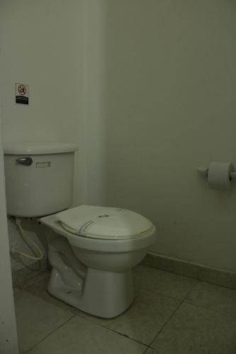 a bathroom with a white toilet in a room at Hotel & Resort Villa del Sol in Tumaco