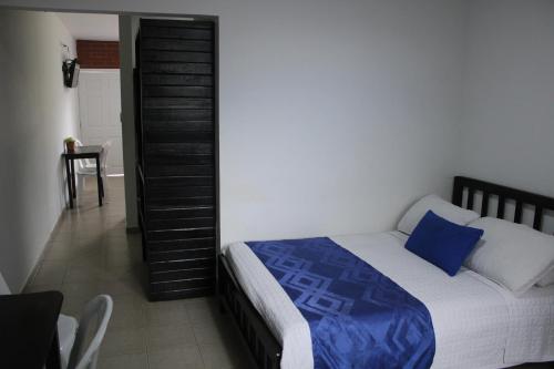 a bedroom with a bed and a staircase in the background at Hotel & Resort Villa del Sol in Tumaco