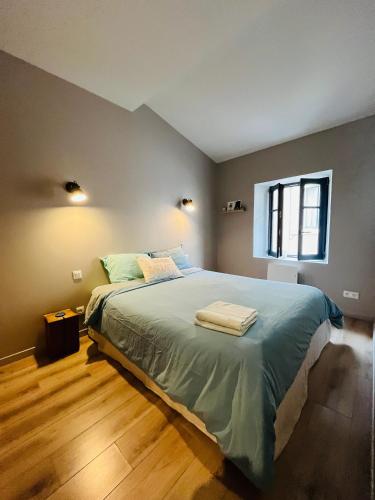 une chambre avec un grand lit et une fenêtre dans l'établissement Maison petite côte, à Carcassonne