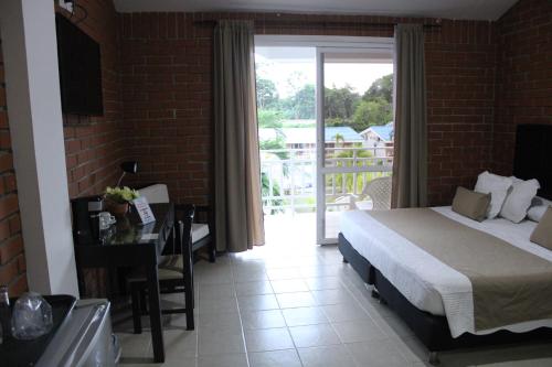 a bedroom with a bed and a door to a balcony at Hotel & Resort Villa del Sol in Tumaco