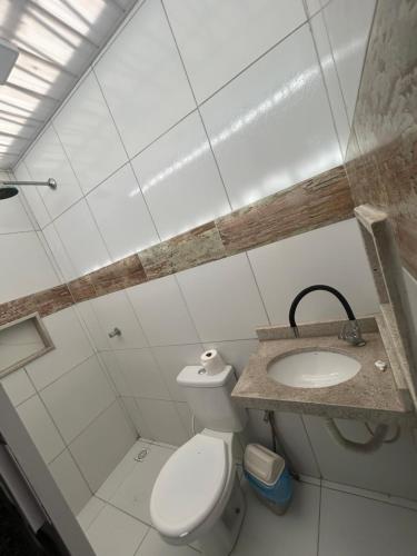 a bathroom with a toilet and a sink at Residencial Salinas in Tibau