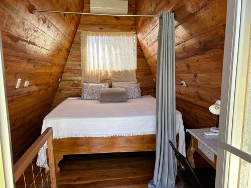 a bedroom in a log cabin with a bed at IkI Tiny Villa in Fortuna
