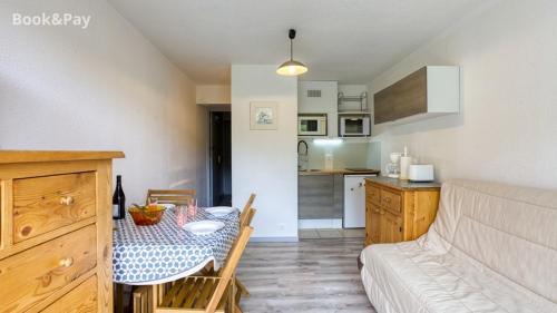 un salon avec une table et une cuisine dans l'établissement Studio soyouz, à Villarembert