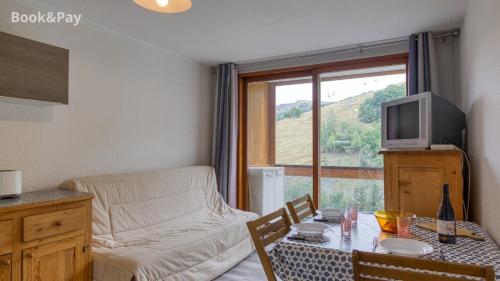 un salon avec un canapé, une table et une télévision dans l'établissement Studio soyouz, à Villarembert