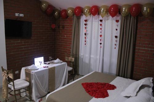 a room with a bed with a table and balloons at Hotel & Resort Villa del Sol in Tumaco