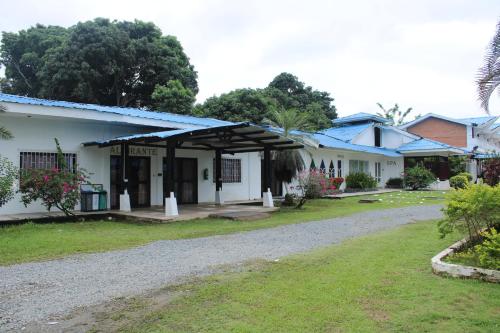a white building with a blue roof at Hotel & Resort Villa del Sol in Tumaco