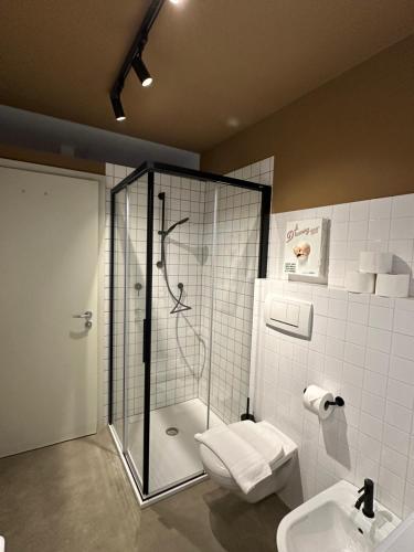 a bathroom with a shower and a toilet and a sink at ADAM Suites - Brixen Card included in Bressanone