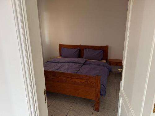 Schlafzimmer mit einem Bett mit lila Bettwäsche und blauen Kissen in der Unterkunft Villa Kary in Arona