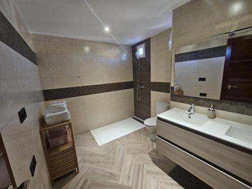 a bathroom with a sink and a toilet and a mirror at Duplex El Balcón de María in Montefrío
