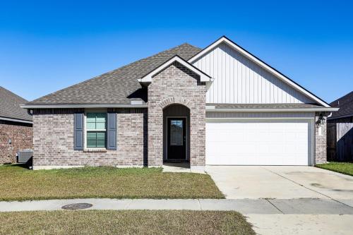 a brick house with a white garage at 13 Mi to Baton Rouge Family-Friendly Home in Zachary