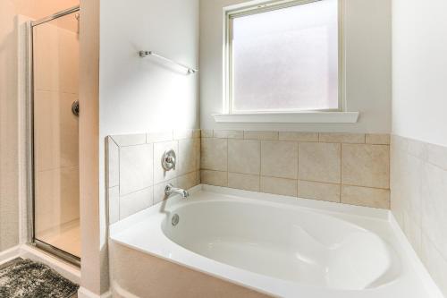 a white bath tub in a bathroom with a window at 13 Mi to Baton Rouge Family-Friendly Home in Zachary