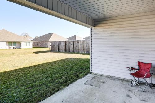 a red chair sitting next to a garage at 13 Mi to Baton Rouge Family-Friendly Home in Zachary