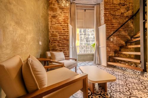 a living room with a couch and a stairway at Hotel Villa Alta Guest House in Cartagena de Indias