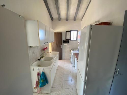 Una cocina con fregadero y refrigerador blanco. en Villa panoramic - Dream and Suite Lodge, en Vico