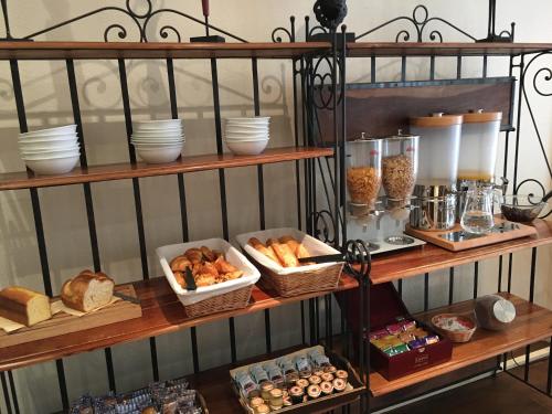 a shelf filled with different types of bread and pastries at Hotel Antin St Georges in Paris