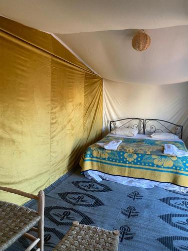 a bedroom with a bed in a tent at Desert Erg Chegaga Camp in El Gouera