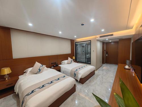 a hotel room with two beds and a projection screen at Royal International Hotel & Mall in Georgetown