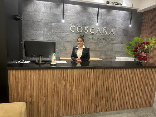 Una mujer parada en un mostrador de recepción en una habitación. en Coscaña Uyuni Hotel by Toloma, en Uyuni