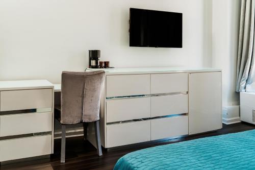 a bedroom with a dresser and a desk with a television at Congress Plaza Hotel Chicago in Chicago
