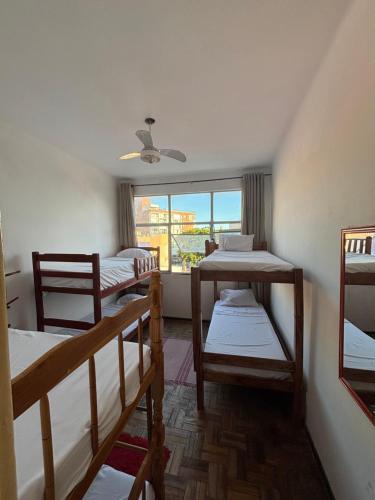 a room with three bunk beds and a window at Barra Mar in Salvador