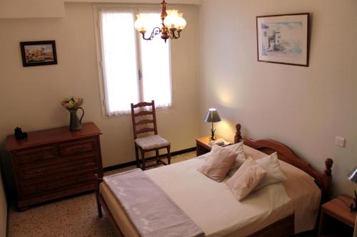 1 dormitorio con 1 cama, 1 silla y 1 ventana en Ta Maria, en Céret
