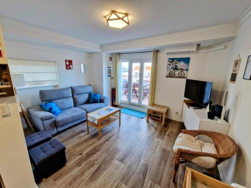 a living room with a blue couch and a tv at Amazing Terrace Costa da Caparica in Costa da Caparica