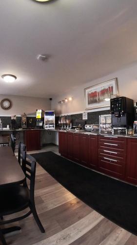 a fast food restaurant with a counter and a bar at Moonlight Inn and Suites Sudbury in Sudbury
