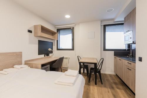 a room with a bed and a desk and a kitchen at Micampus Santander Student Residence in Santander