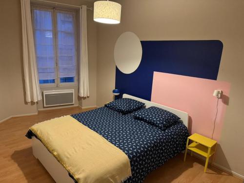 - une chambre avec un lit doté d'une tête de lit bleue et d'une fenêtre dans l'établissement Klein, à Clermont-Ferrand