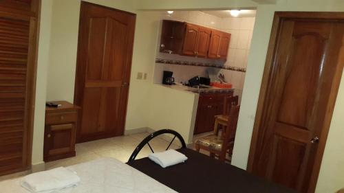 a small kitchen with wooden cabinets and a table at Hostal Bocas Tropical Paradise in Bocas del Toro