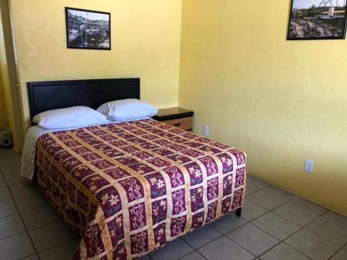 a bedroom with a bed with a bedspread on it at Scoot Inn in Port Orange