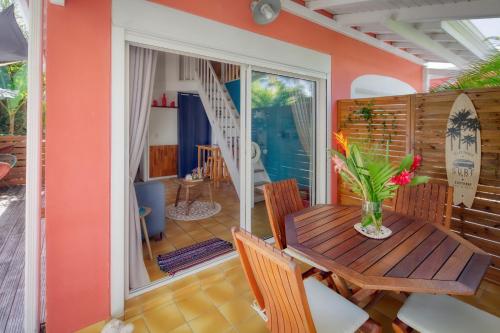 a dining room with a wooden table and chairs at Villa Petite Terre à 50 mètres de la plage in Saint-François
