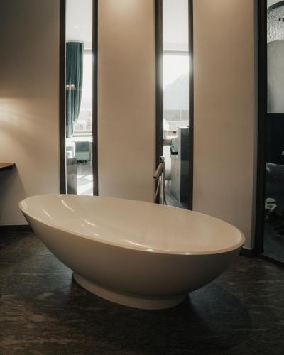 a white bath tub in a bathroom with windows at Hotel Bad Fallenbach in San Leonardo in Passiria