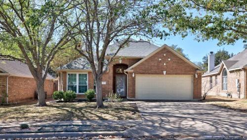 a brick house with a garage and two trees at Artist Retreat at Cypress Creek - Hotub - Sleeps 9 in Cedar Park