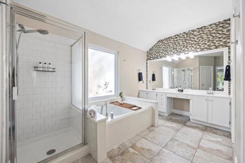 a bathroom with a tub and a shower and a sink at Artist Retreat at Cypress Creek - Hotub - Sleeps 9 in Cedar Park