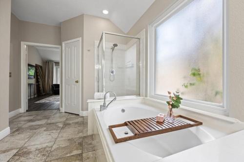 a large bathroom with a tub and a window at Artist Retreat at Cypress Creek - Hotub - Sleeps 9 in Cedar Park