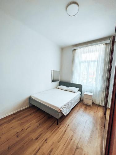 a bedroom with a bed and a wooden floor at Appartamento in villa antica a pochi passi dal lago in Minusio