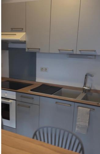 a kitchen with white cabinets and a table with a chair at T2 cozy, ultra-center Papeete - Fare Mauz in Papeete